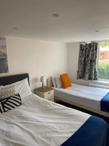剑桥The Cambridge Suites - Tas Accommodations的一间卧室设有两张床和窗户。