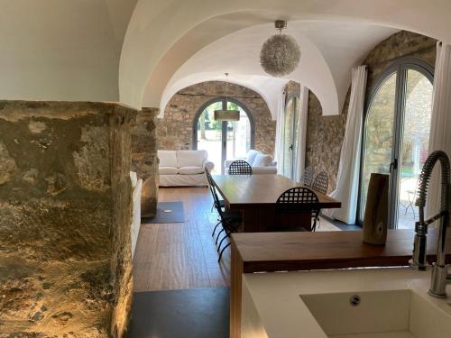 圣霍安-莱斯丰特斯Casa Rural el Serrat de Baix的用餐室和带石墙的客厅