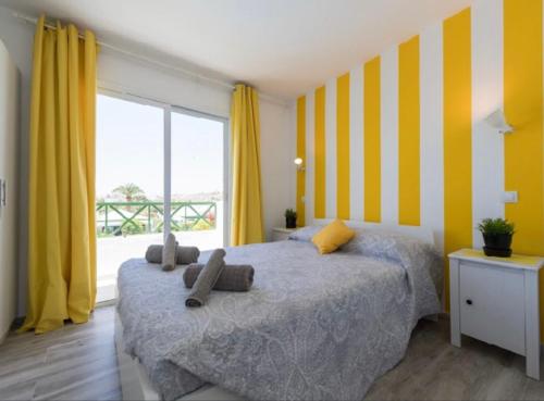 马斯帕洛马斯Sweet apartment maspalomas的一间卧室配有一张黄色和白色条纹的床