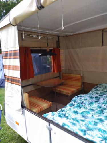 TynaarloRetro Vouwwagen的卧室和拖车内的一张床