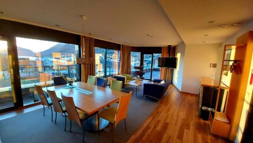 厄什塔Havila Hotel Ivar Aasen的一间带桌椅的用餐室和一间客厅