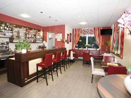 兰斯科伦斯坎平佩什孟特旅馆的一间拥有红色墙壁的餐厅和一间设有红色椅子的酒吧