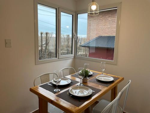 埃尔卡拉法特South Apartments的一间带桌椅和窗户的用餐室