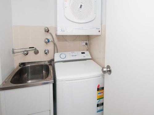 霍克斯内斯特Providence Apartment 3的一个带水槽和洗衣机的小厨房