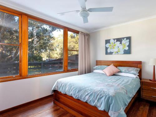 霍克斯内斯特Gumtree Cottage Hawks Nest的一间卧室设有一张床和一个窗口