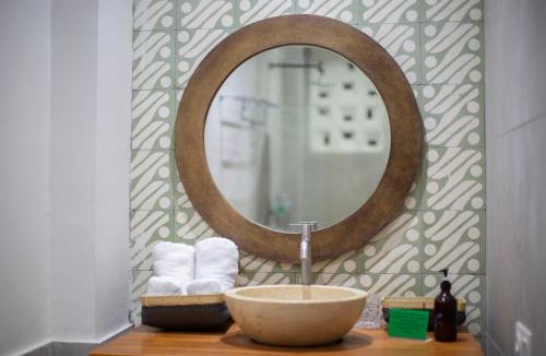纳闽巴霍生态树奥特尔酒店的浴室设有水槽和镜子,位于柜台上