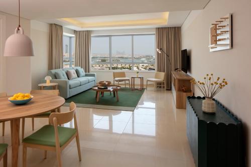 迪拜Staybridge Suites Dubai Internet City, an IHG Hotel的客厅配有沙发和桌子