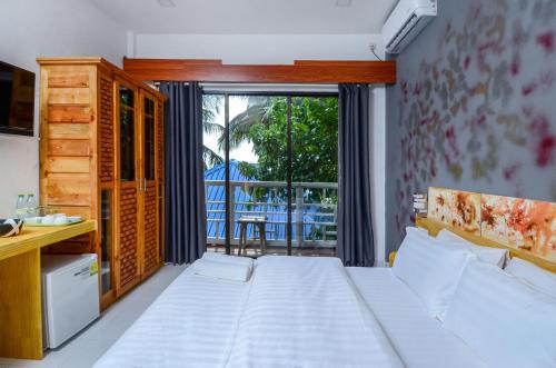 马富施Paradise Retreat, Maafushi的一间卧室设有一张床和一个大窗户