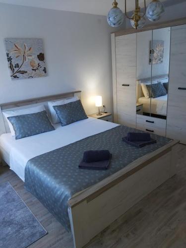 比哈奇Apartman Alma的一间卧室配有一张大床和蓝色枕头
