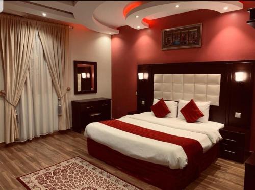 Qarārشاليهات شاطئ ارينا的一间卧室设有一张带红色墙壁的大床