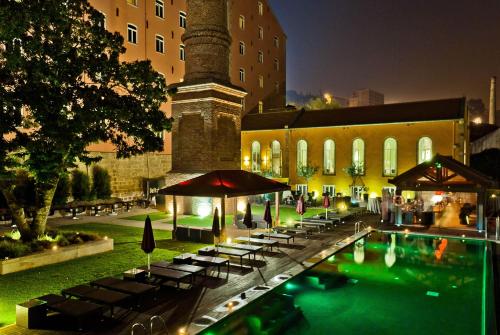 波尔图Pestana Palacio do Freixo, Pousada & National Monument - The Leading Hotels of the World的夜间在大楼前的游泳池