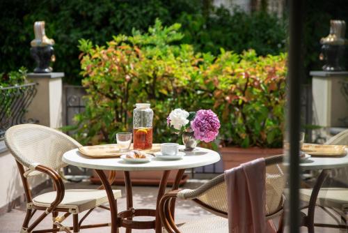 阿奇卡斯泰洛奥坦西亚别墅住宿加早餐旅馆的天井上配有带2把椅子和鲜花的桌子