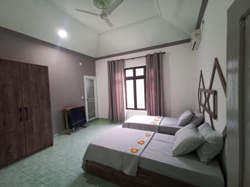 VaikaradhooBoegas View Guesthouse的一间卧室设有两张床和窗户。