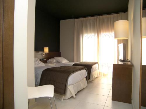 巴达洛纳巴达洛纳旅馆的酒店客房设有两张床和窗户。