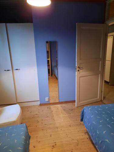 奥卢vierashuone的一间拥有蓝色墙壁的卧室,卧室配有一张床和一扇门