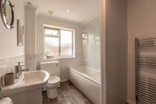 南安普敦Luxury Southampton house with garden and parking的浴室配有盥洗池、卫生间和浴缸。
