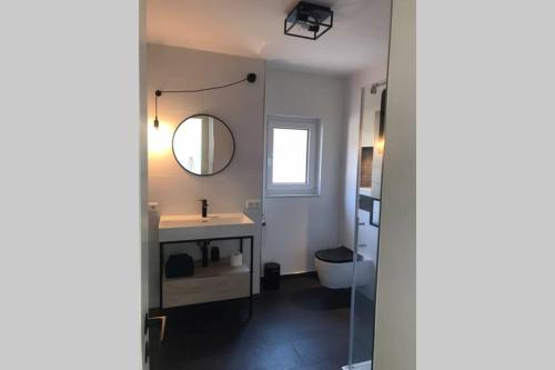 拉博埃Cosyinlaboe的一间带水槽、镜子和卫生间的浴室