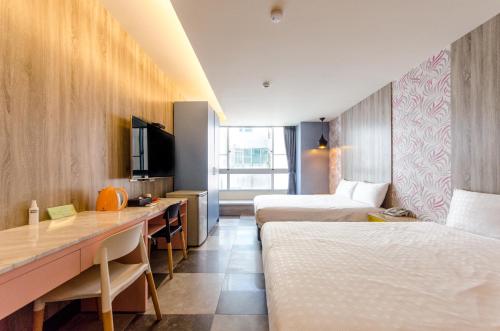 台南郡象商旅的酒店客房配有两张床和一张书桌