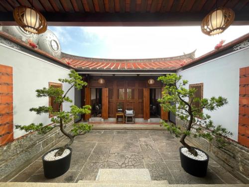 金宁乡金門古寧歇心苑官宅古厝民宿 Guning Xiexinyuan Historical Inn的两棵树房子的庭院