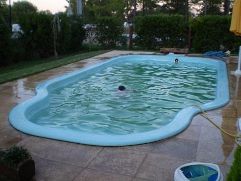 科隆Pinares de Colon的游泳池,有人在里面游泳