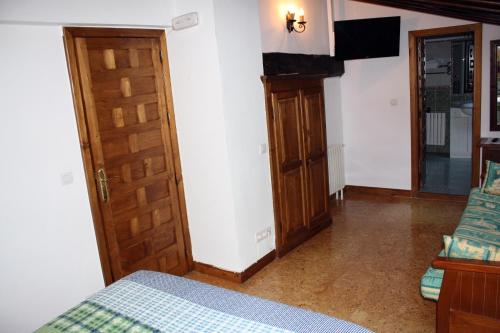 桑提亚纳德玛安赫利卡旅馆的一间卧室配有一张床和一扇木门
