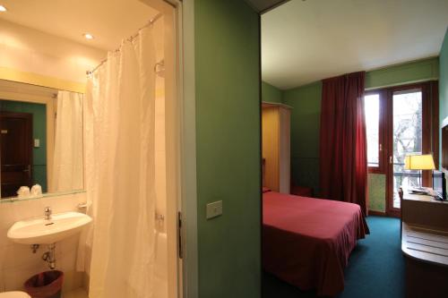 佛罗伦萨梅里蒂安娜酒店的一间带水槽的浴室和一张位于客房内的床