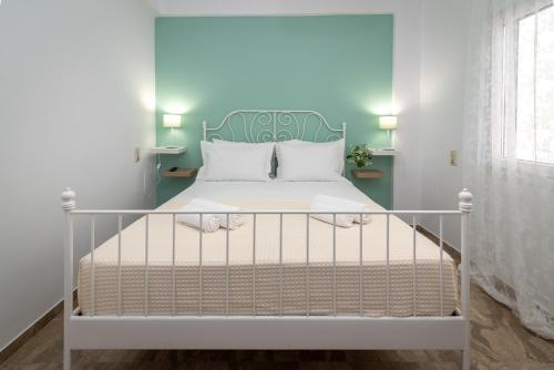 赫索尼索斯Casa EleMar Villa with Private Yard的一间卧室配有一张白色床和绿色床头板