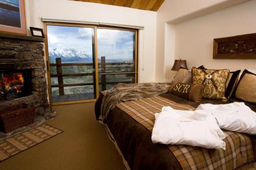 杰克逊斯普林克里克牧场酒店的卧室配有床、壁炉和窗户。