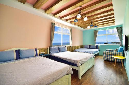 绿岛Qing Feng Diving B&B的客房设有两张床、一台电视和窗户。