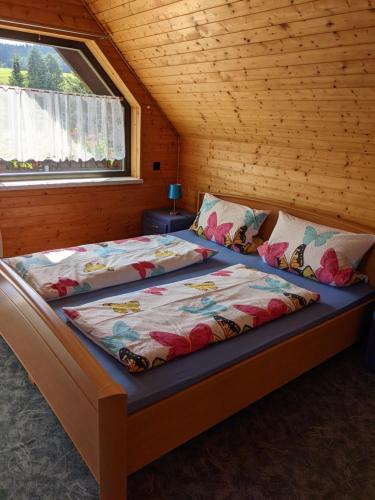 CranzahlFerienhaus an der Fichtelbergbahn的木制客房内的一间卧室配有两张床