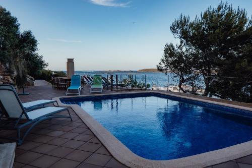 阿达亚港门努尔卡-阿达亚港酒店的一个带椅子的游泳池,享有水景