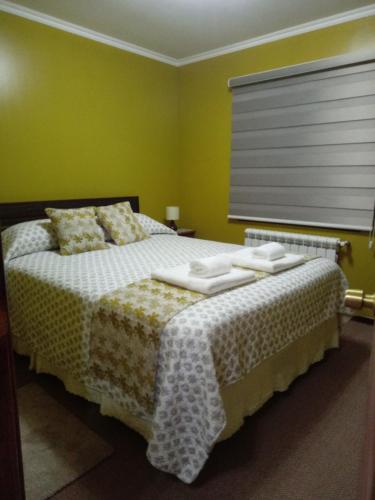 蓬塔阿雷纳斯VALYAK rent apart hotel - Servicios Integrales的一间卧室配有一张带白色床单的床和一扇窗户。