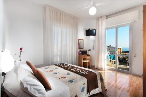里米尼杜拉克酒店的一间卧室配有一张床,享有海景