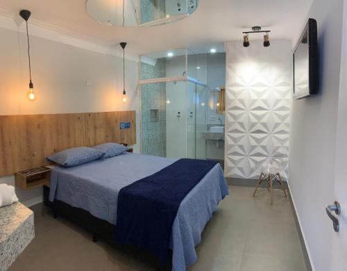 圣保罗Bob Motel的一间卧室配有蓝色的床和淋浴