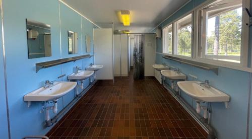 胡迪克斯瓦尔Hostel Hudiksvall Malnbaden Camping的浴室设有4个水槽和一排镜子