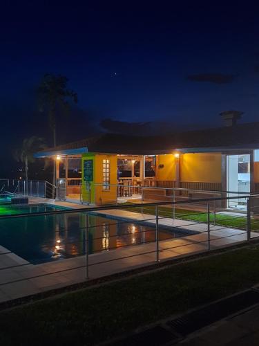 佩雷拉Ecohotel Guaduales Pereira的一座晚上设有游泳池的建筑