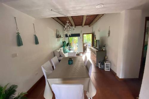 ManantialesAlmarena, tu casa en Punta del Este的一间带桌子和白色椅子的用餐室