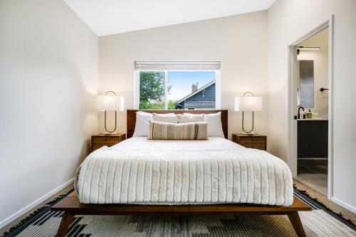 西雅图The Treehouse的一间卧室配有一张带两盏灯的床和一扇窗户。