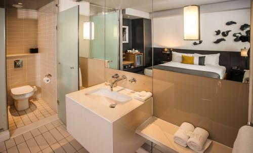 约翰内斯堡Piazza Hotel Montecasino的一间带水槽和卫生间的浴室以及一张床