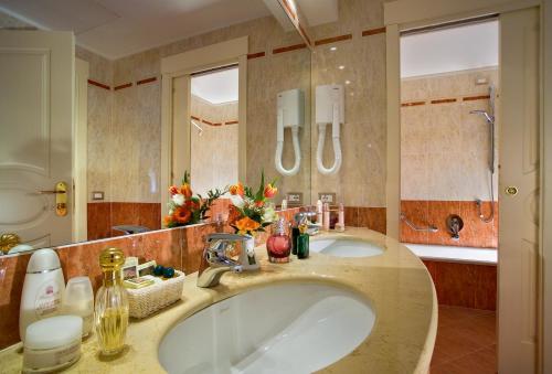 阿巴诺泰尔梅布里斯托尔布加酒店的一间带两个盥洗盆和大镜子的浴室