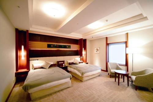 秋田秋田城堡酒店的酒店客房设有两张床和一张桌子。