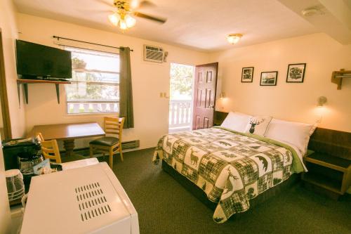镭温泉山地温泉汽车旅馆的一间卧室配有一张床、一张桌子和一张桌子
