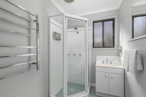 蒙恩维优山景小屋酒店的带淋浴和盥洗盆的白色浴室
