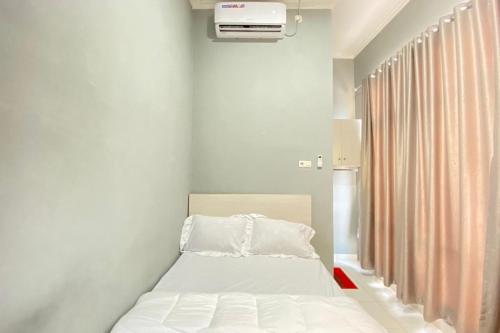 Talang KelapaPelangi Guest House Palembang RedPartner的一间小卧室,配有床和窗户