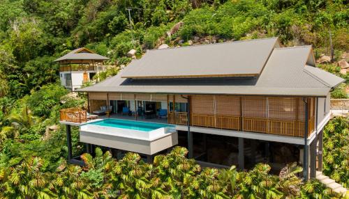塔卡马卡Paradise Chalets Yoga & Wellness的享有带游泳池的房屋的空中景致