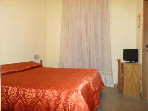 斯培西亚奥罗拉酒店的一间卧室设有一张床和一个带电视的窗户。