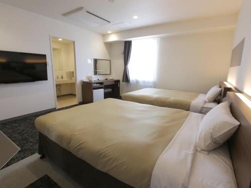 Hotel New Gaea Nishi Kumamoto Ekimae客房内的一张或多张床位