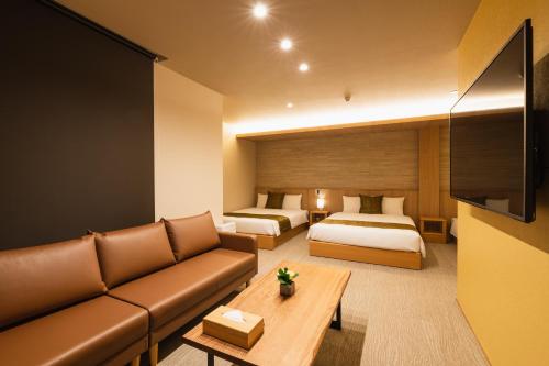 长崎GRAND BASE Nagasaki Nakamachi的酒店客房设有一张沙发和一张床