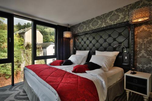 克莱沃Le Clervaux Boutique Hotel & Spa的一间卧室设有两张床和大窗户