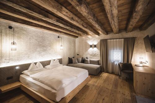 拉松迪索托Autentis的卧室配有一张白色的大床和一张沙发。